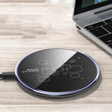 Wireless charging pad on a wooden surface with a laptop in the background