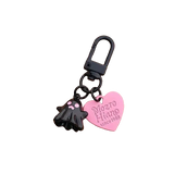 Keychain with black cat-shaped charm and pink heart-shaped tag on a white background