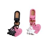 Two keychains, one black and one pink, with heart-shaped tags and a dog design on a white background.