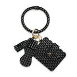Black rubber band keychain with a small bag charm on a white background