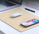 Wooden desk mat with laptop, mouse, smartphone, and pen on a white surface