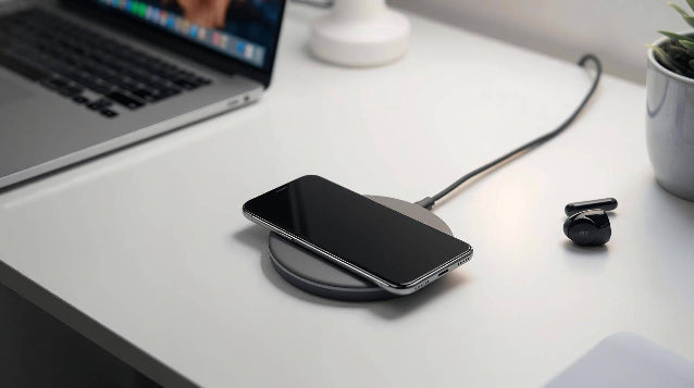 smartphone charging on a wireless charging pad on a clean fresh white desk