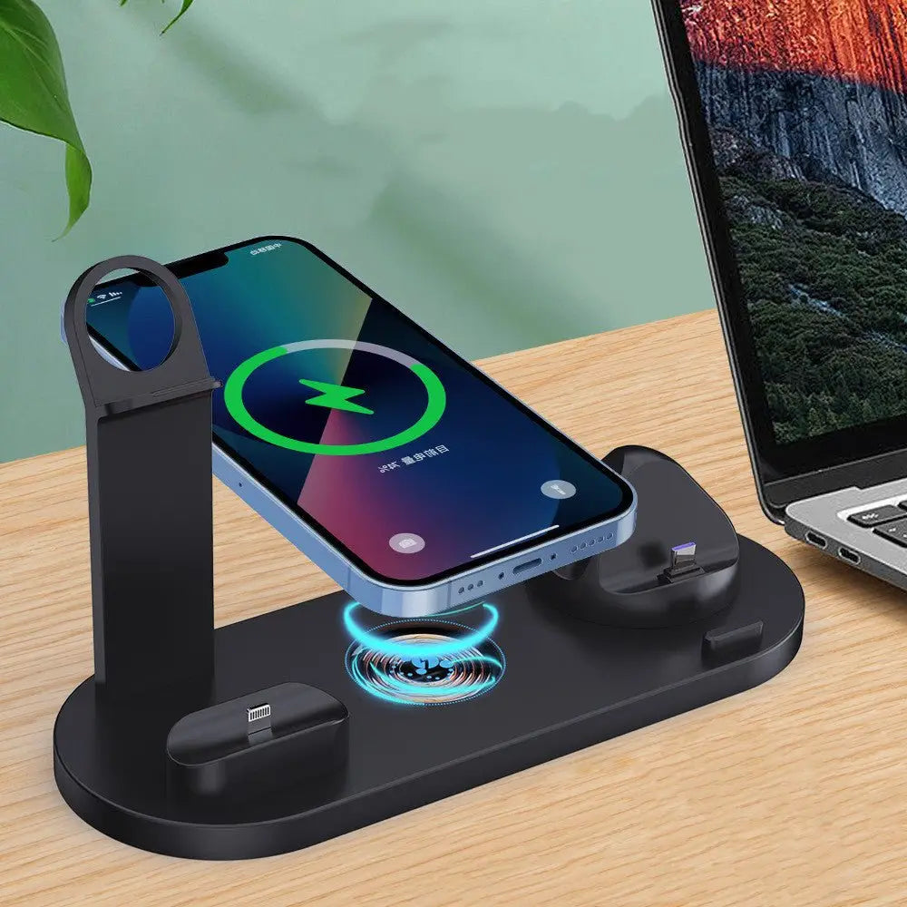 Multi-device charging station with smartphone, laptop, and wireless charger on a wooden surface.
