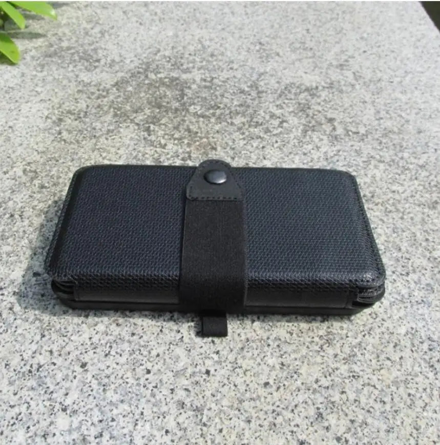Black textured wallet on a gray concrete surface