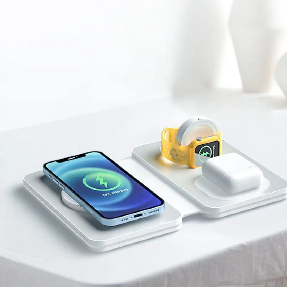 Wireless charging pad with smartphone, smartwatch, and headphones on a white surface