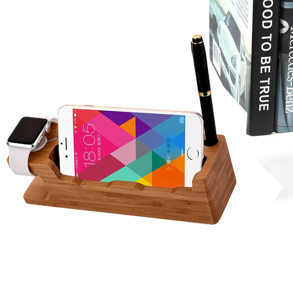 Wooden charging station with smartphone, smartwatch, and pen on a white surface.