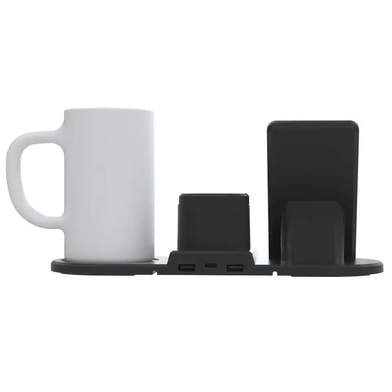 White mug on a black coaster with a black phone stand and small black box on a white background