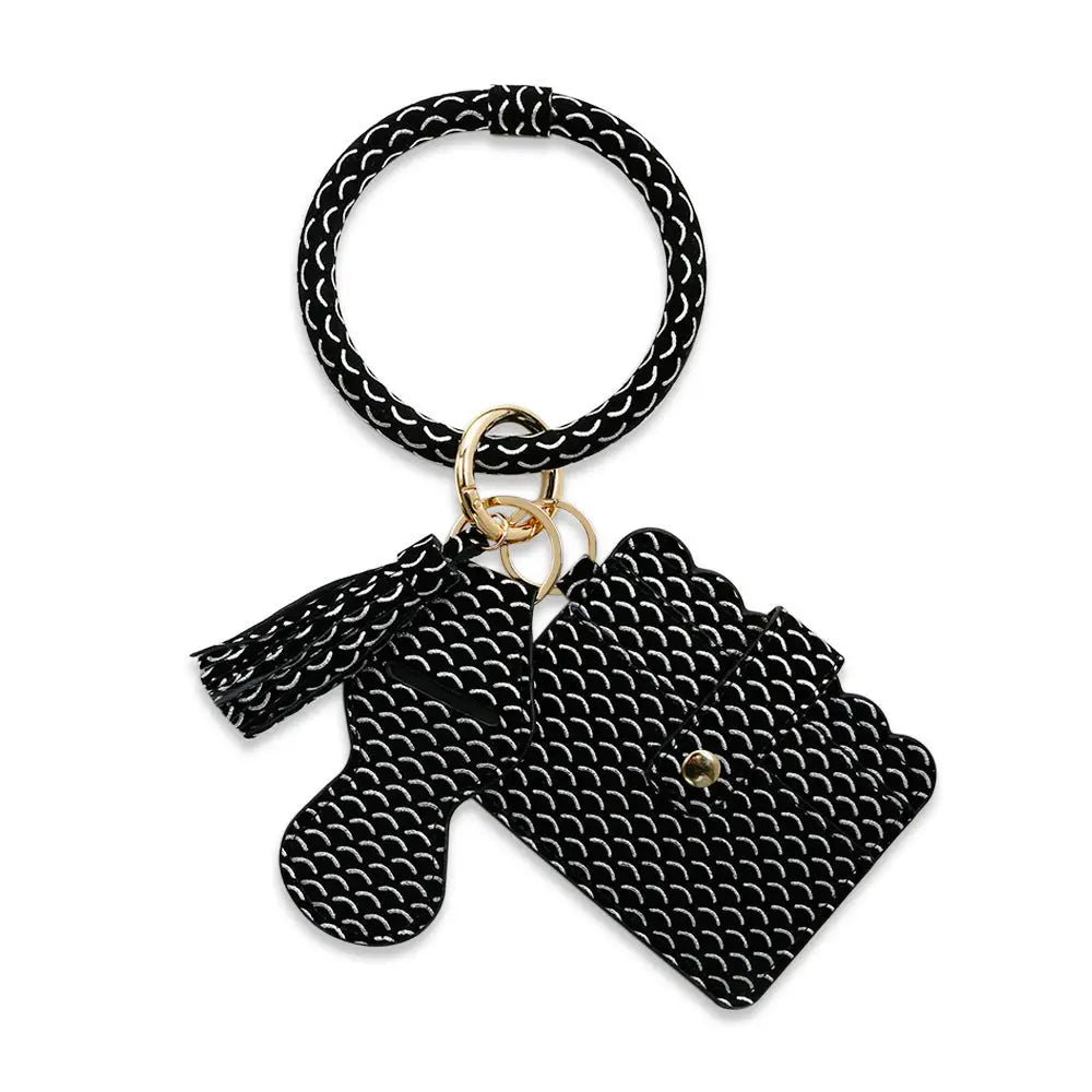 Black rubber band keychain with a small bag charm on a white background