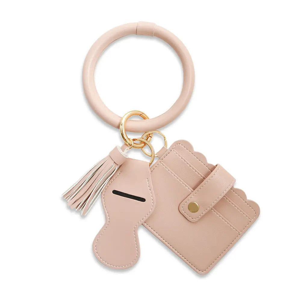 Pink keychain with a small pouch and tassel on a white background