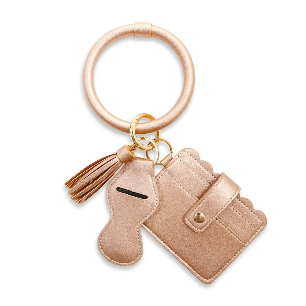 Beige keychain with card holder and tassel on a white background